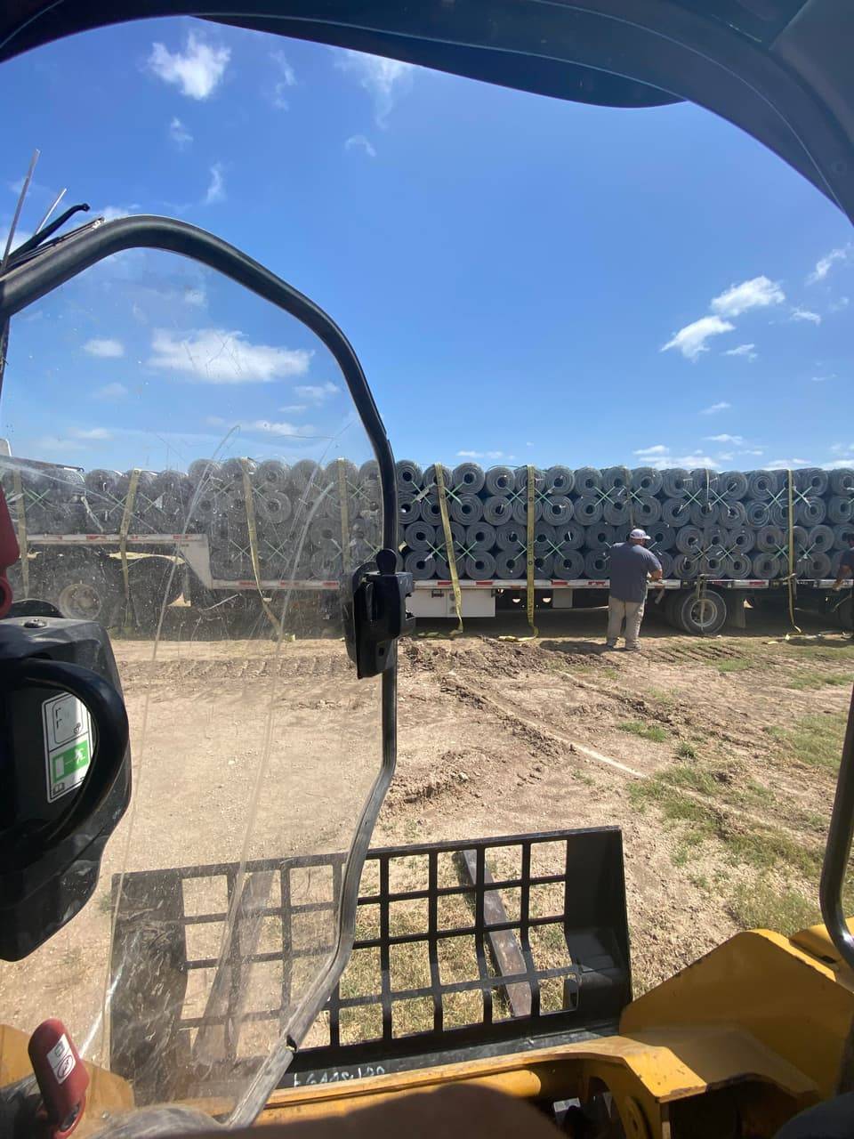 Rolls of wire fencing material staged on flatbed trailers at a Linn's Fencing job site in Bosque County, Texas.