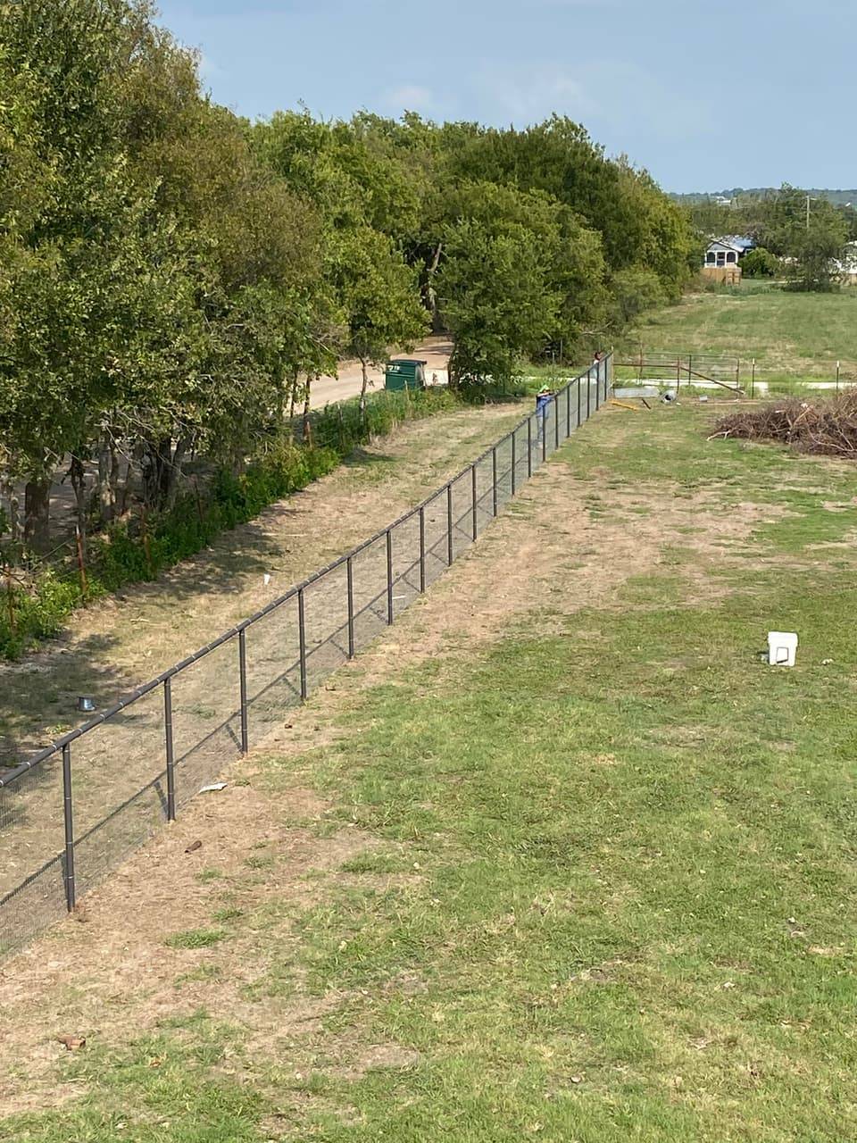 Ranch & Farm Fencing example — Vinyl-coated wire mesh fence along a rural property line, Central Texas rural property